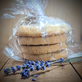 Lavender Connection Lavender Shortbread Cookies, package of 4, in plastic airtight bag, sitting on rustic wood table